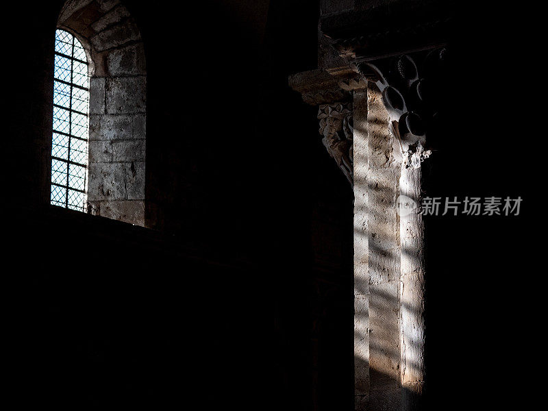 一座老建筑的内部镜头，阳光透过窗户照射在柱子上