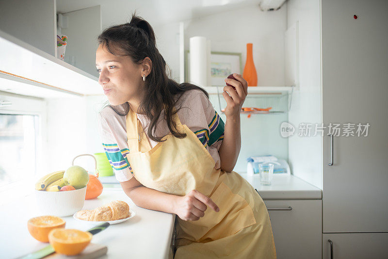 年轻漂亮的女人在厨房吃早餐