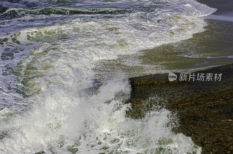 汹涌的海浪撞击着岸边的岩石