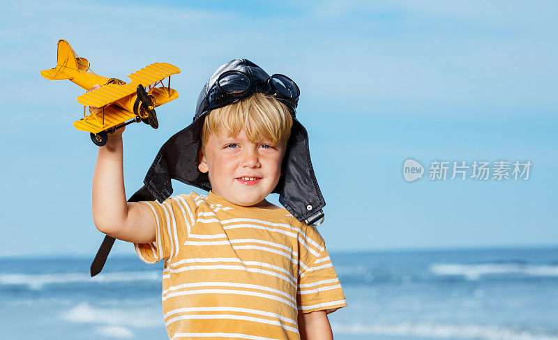 一个小男孩站在玩具模型飞机的肖像