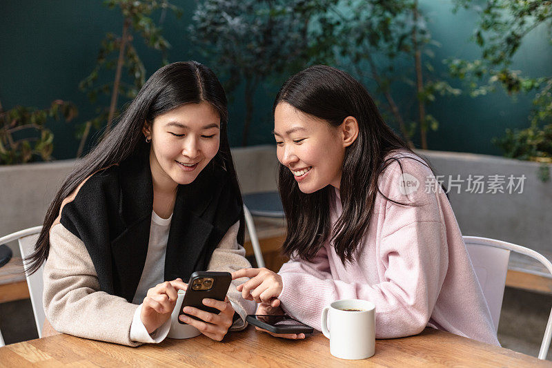 女性朋友在咖啡馆边喝咖啡边看智能手机上的任何内容