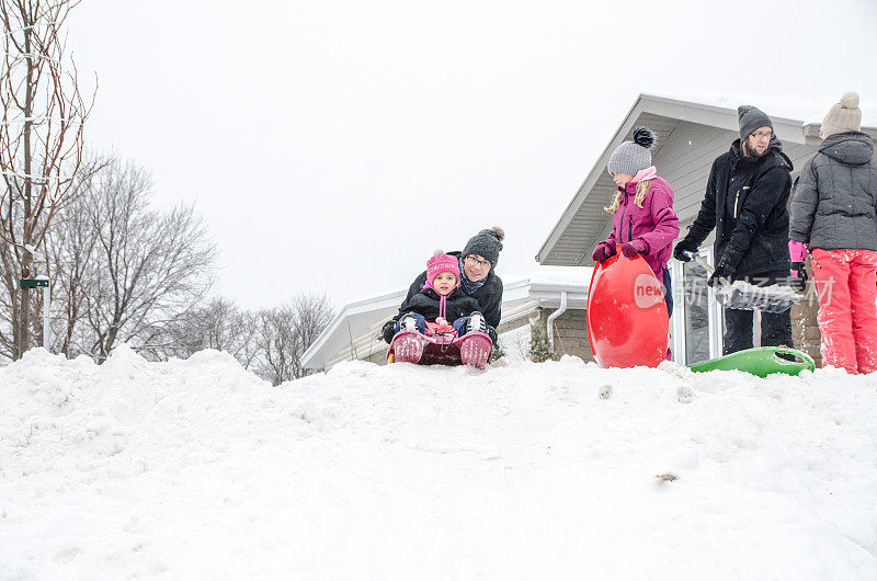 孩子和父母在雪地上滑行