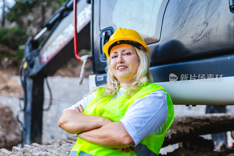 图为一名在建筑工地工作的女挖掘机司机