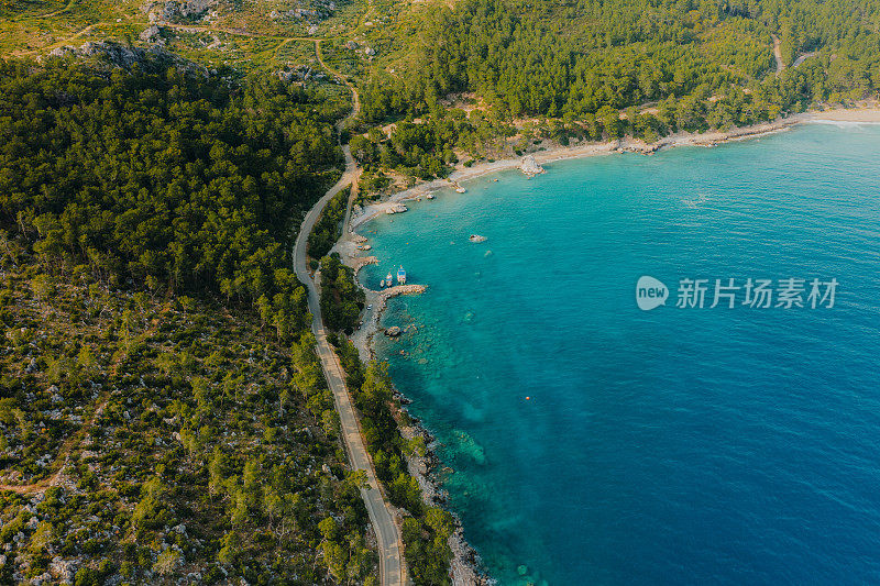 鸟瞰图，汽车行驶在土耳其森林和绿松石海的弯曲道路上