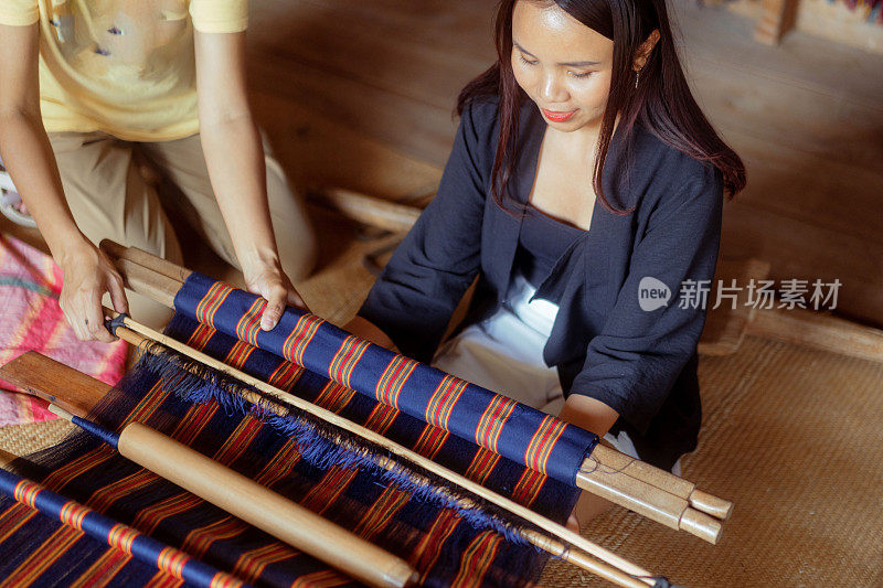 年轻的印尼妇女学习手工编织传统的Tenun布