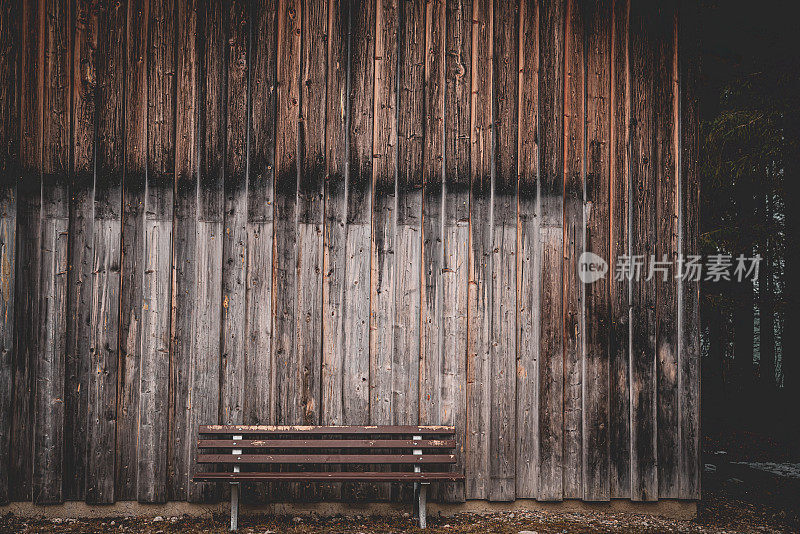 松树林中风化小屋的长凳和山墙