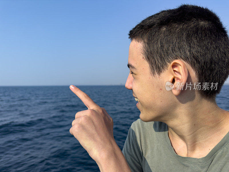 这个男孩正在北爱琴海的一艘男孩游船上旅行。体贴又快乐。晴朗的夏日。旅游的背景。旅游的概念。