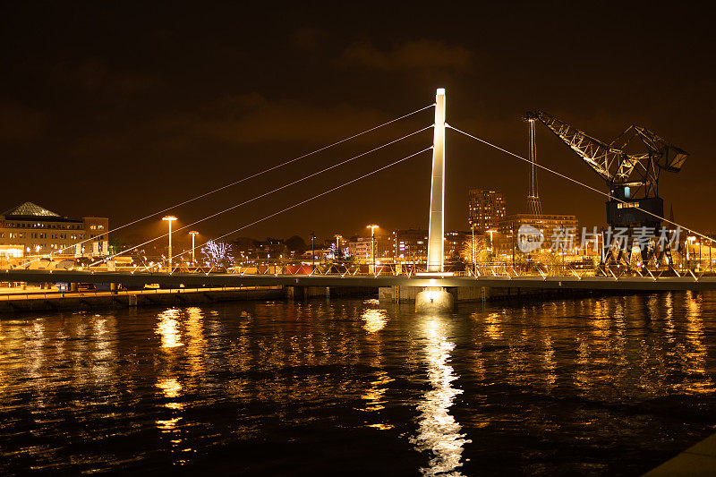 雄伟的桥梁横跨波光粼粼的水面在夜间。Helsingborg,瑞典