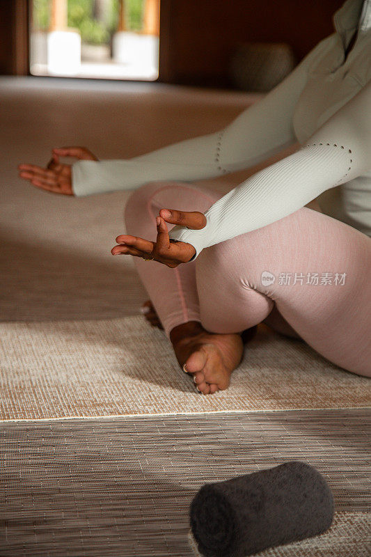 非裔美国妇女盘腿坐在瑜伽垫上练习瑜伽冥想和正念