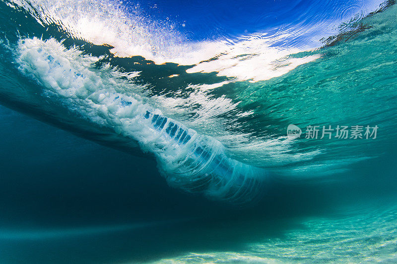 在清澈的海水中，海浪拍打着沙滩，水下的景色一览无余