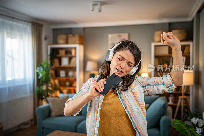 一个年轻的女人喜欢生活的节奏和播放列表上的好音乐