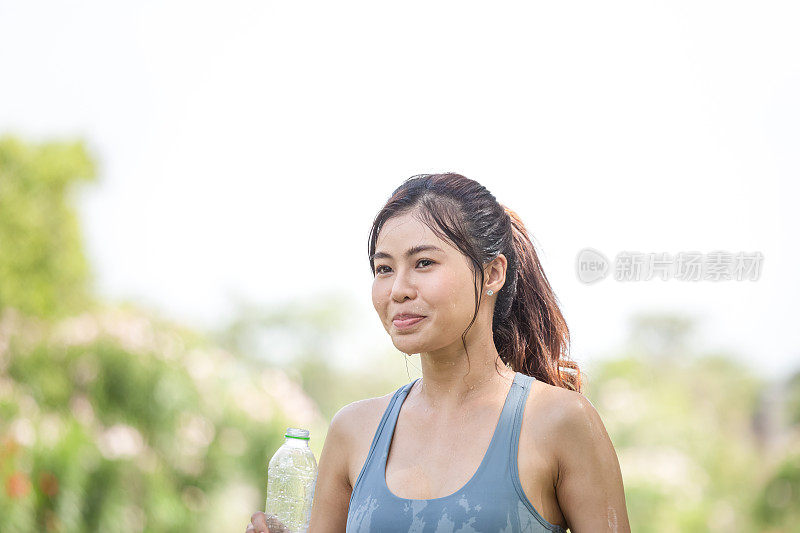 亚洲女运动员通过倒淡水来降温，女性健身者把水倒在她完美的身体上