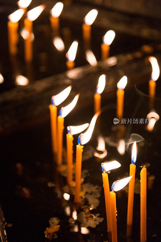 天主教堂内祈祷蜡烛排成一排燃烧着