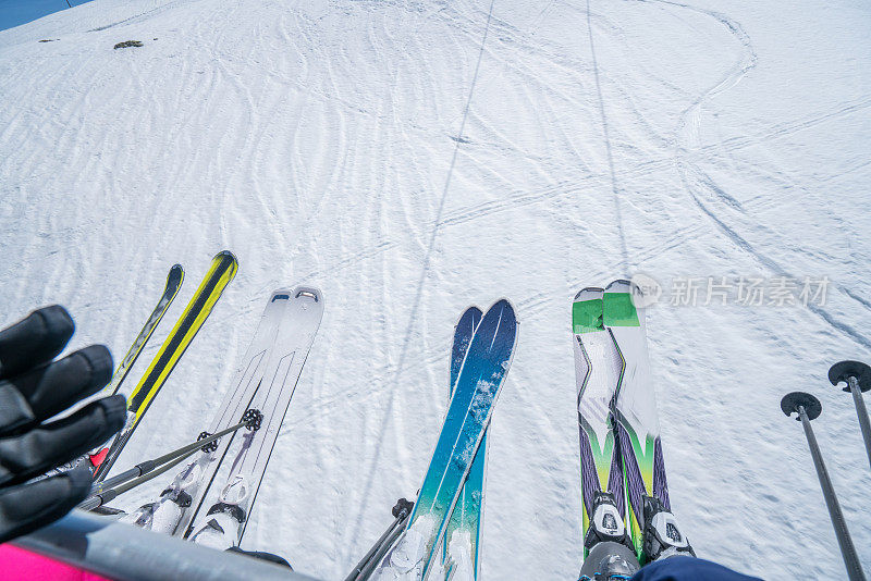 滑雪者从滑雪缆车向下看滑雪板的角度，家庭冬季假期在瑞士滑雪假期团聚