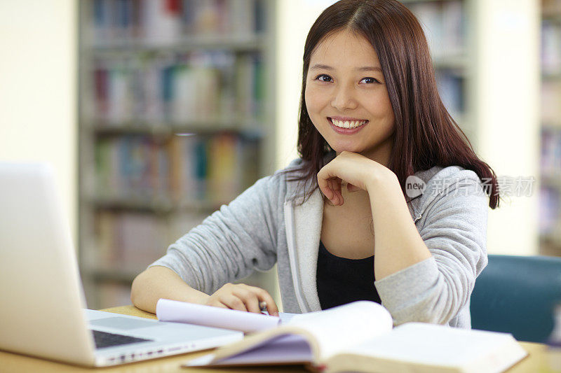 一个漂亮的亚洲女大学生在图书馆学习