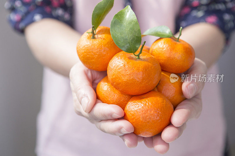 中老年女人捧着橘子