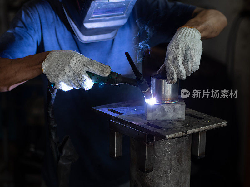 男人的手用氩焊机。维修管道不锈钢氩焊接工业建筑