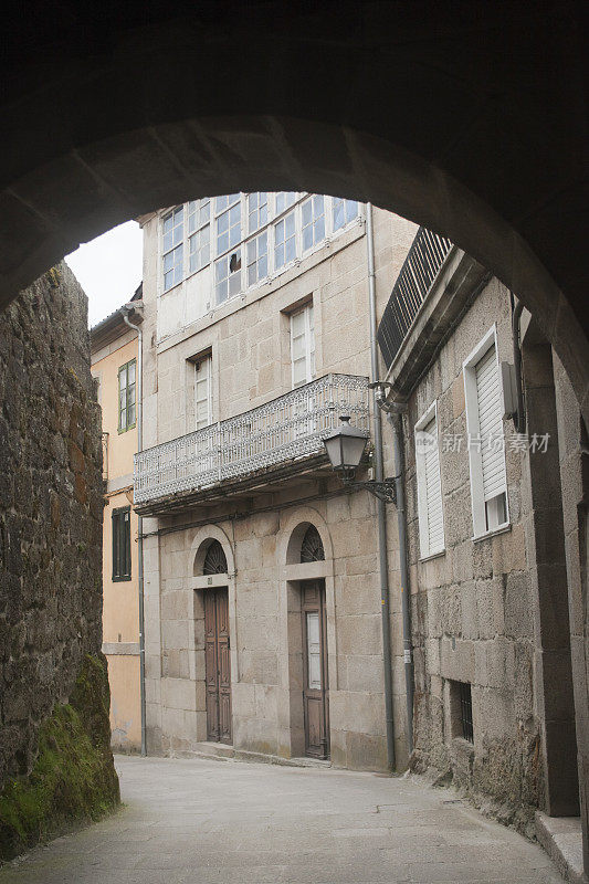 古老的石拱盖在空荡荡的狭窄街道上，西班牙加利西亚。