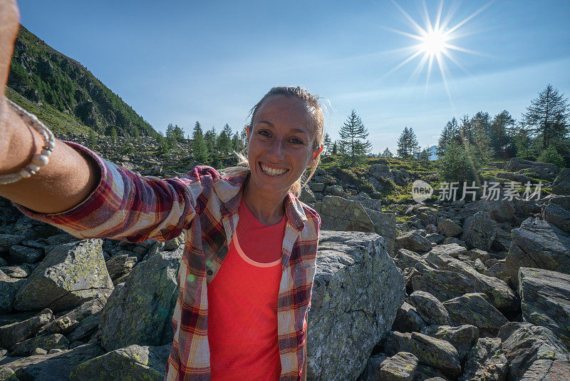 一名年轻女子在山湖边自拍