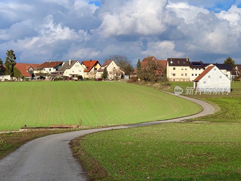 农田和典型的德国小村庄在戏剧性的天空下，一月