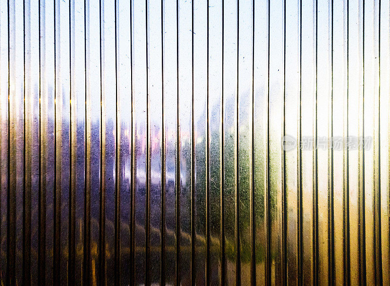黄昏的街景透过划痕的塑料脊窗