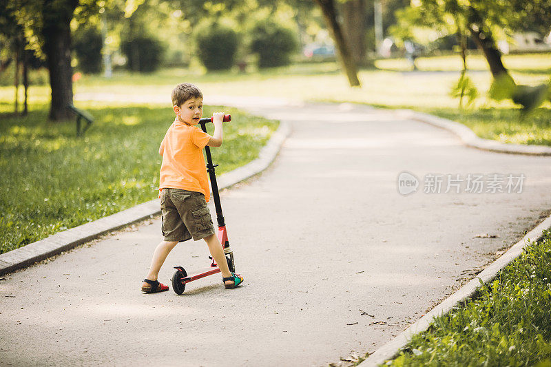 小男孩骑着滑板车
