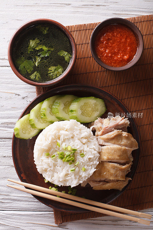 海南鸡饭特写，辣椒酱和肉汤。垂直