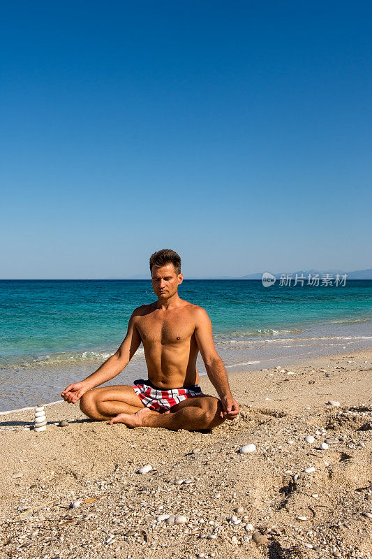 清晨，成年男性在海滩上练习冥想