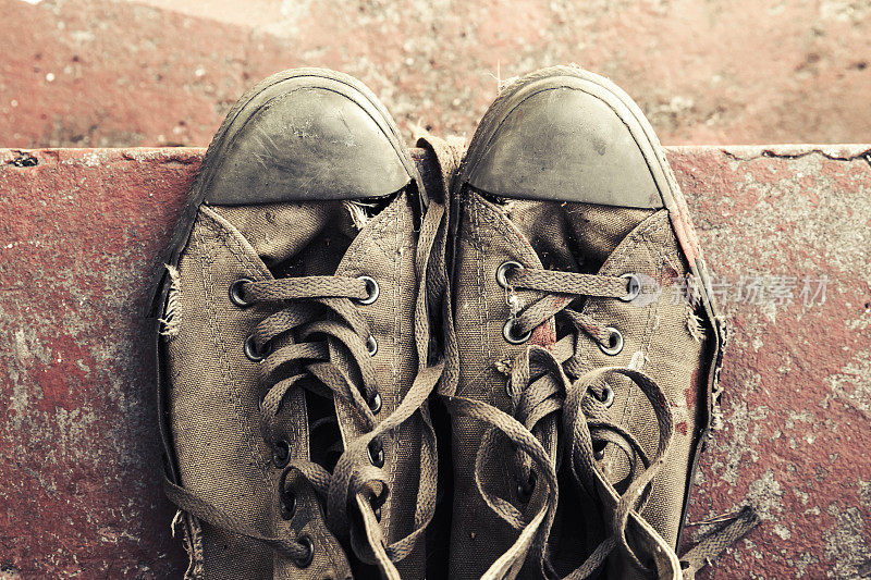水泥楼梯上放着旧运动鞋