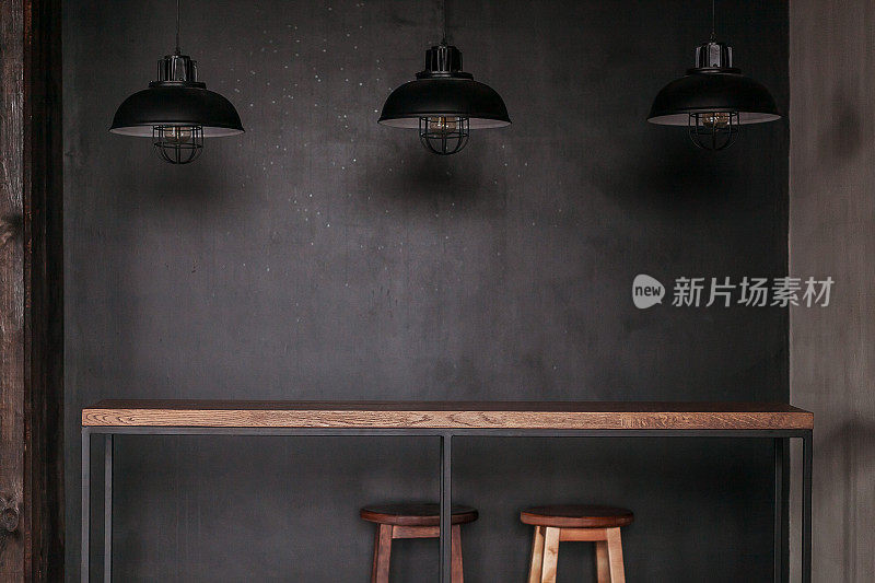 餐桌设置在阁楼风格的餐厅与黑色的灯