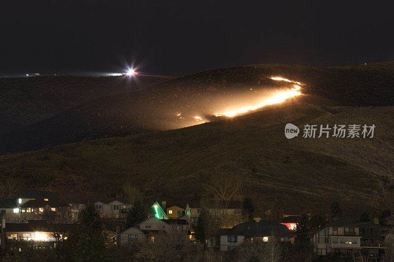 绿色山火，科罗拉多州莱克伍德消防队员在房屋上空燃烧