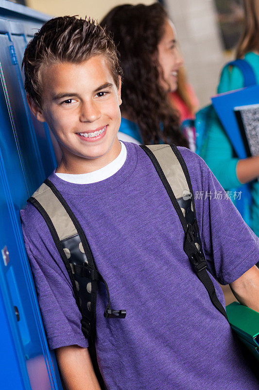高中男生站在学校的储物柜旁