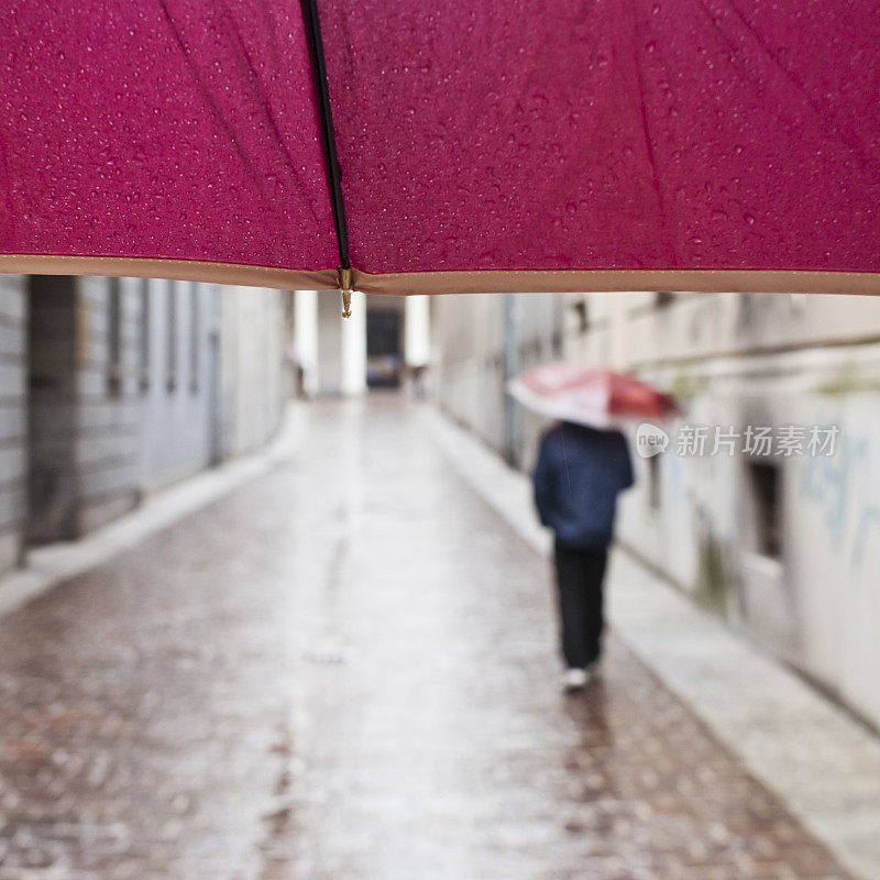 雨伞下的男人在雨天走在街上