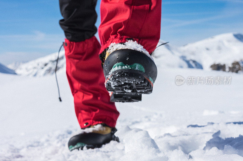 登山运动员的靴子在积雪的小路上