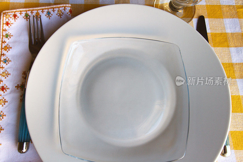 餐具，白色和玻璃盘子，漂亮的餐巾(特写)