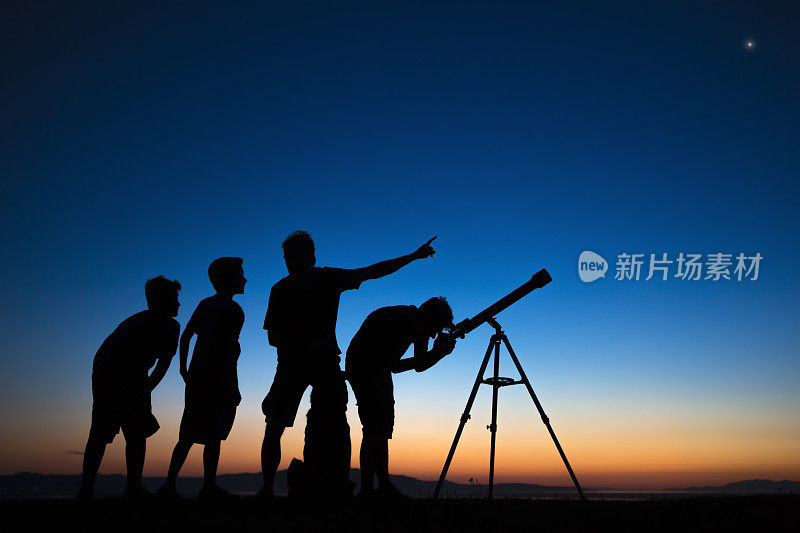 爸爸和三个儿子在用望远镜看东西
