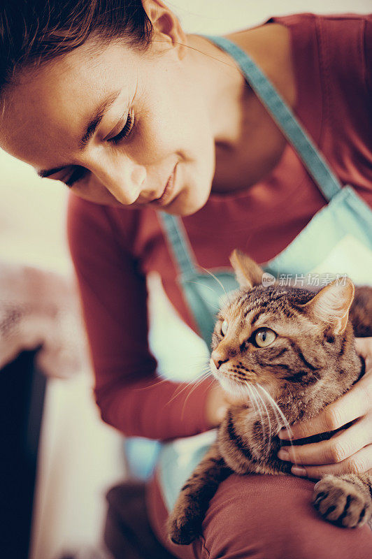 白人妇女在家里爱抚猫