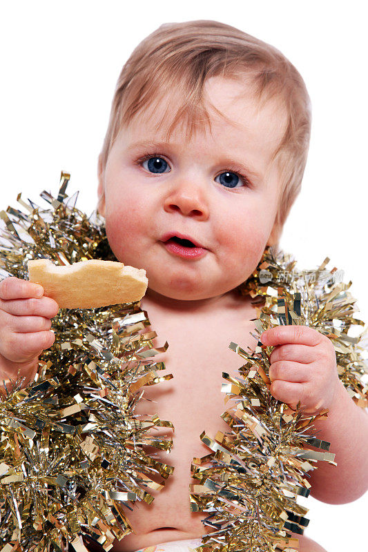 婴儿戴圣诞饰品和吃饼干