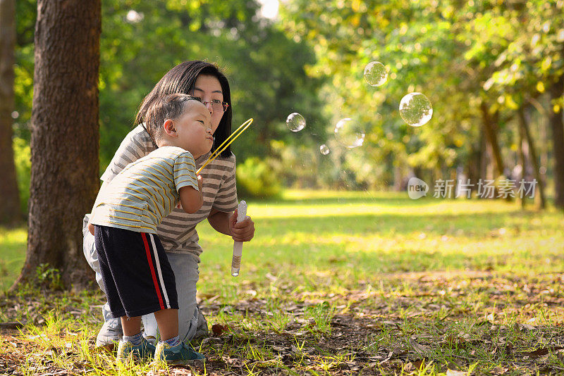 亚洲小孩和妈妈玩泡泡棒