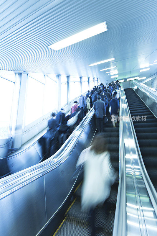 在东京地铁站乘坐自动扶梯的乘客