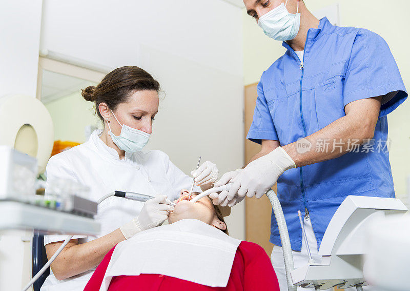 牙医团队在工作……女牙医和她的男助手