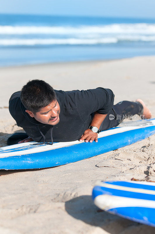 冲浪教练在沙滩上演示技巧