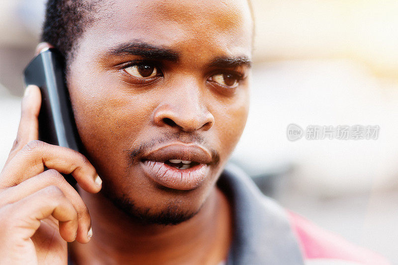 一个年轻的黑人在用手机严肃地说话