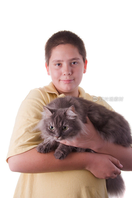 一个十几岁的男孩抱着一只灰色的西伯利亚猫