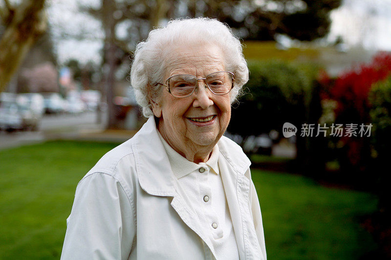 微笑的老奶奶在户外穿着白色的衣服