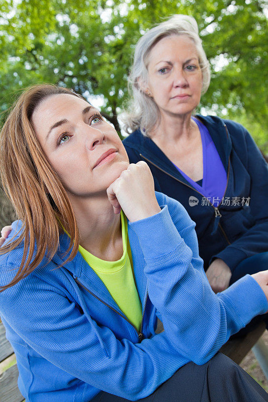 体贴的年轻女人和她关心的母亲在公园里