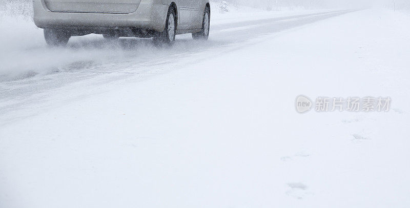 暴风雪在冬季森林的道路上