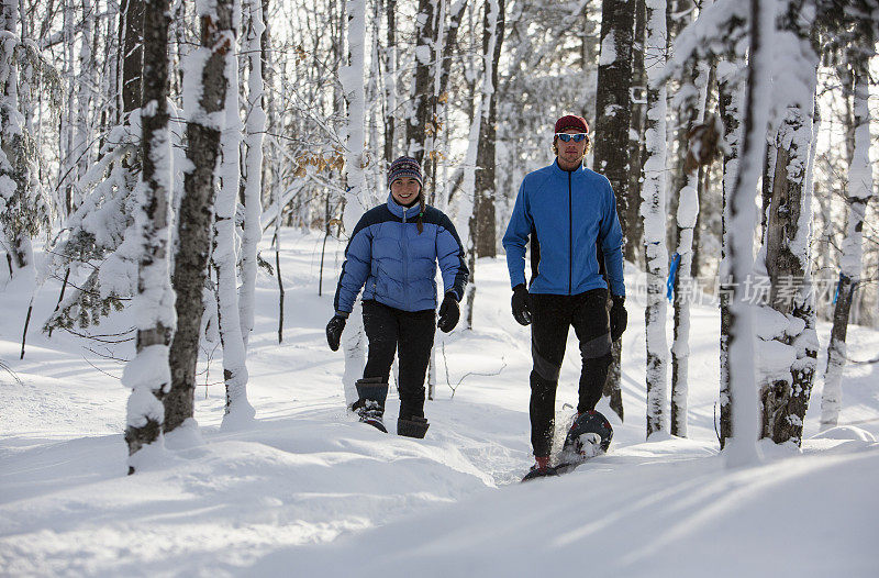 一对穿雪鞋的夫妇在一个晴朗的冬日在中西部。