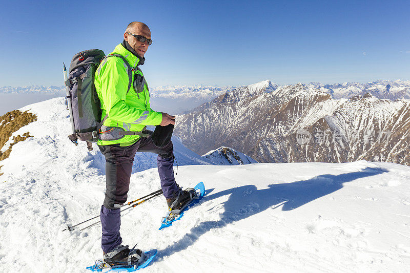 在山顶上穿着雪鞋的徒步旅行者