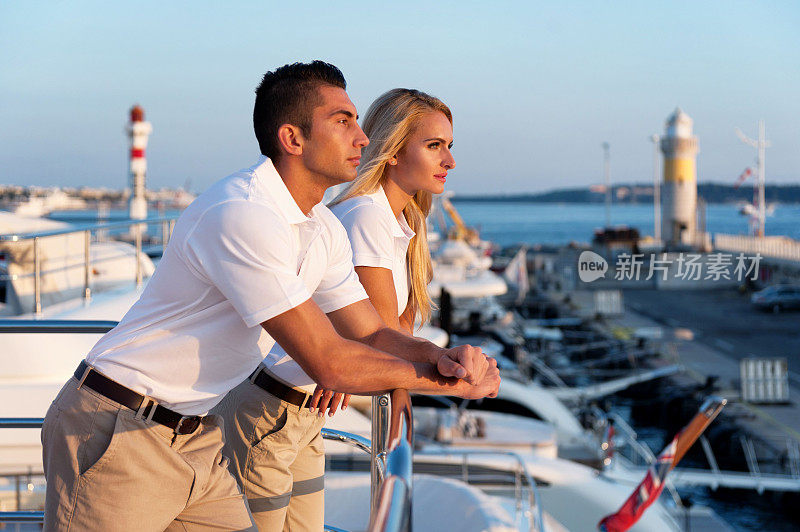 年轻夫妇在游艇上欣赏日落